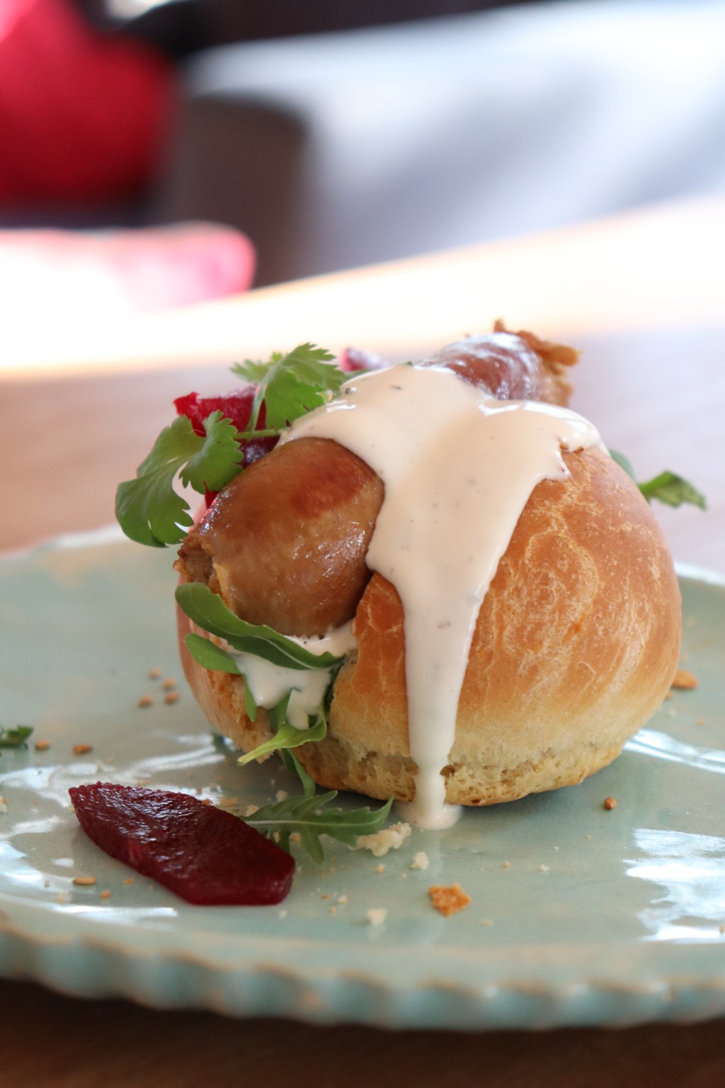 Indische worstjes tussen een broodje met rode biet en knoflook-yoghurtsaus